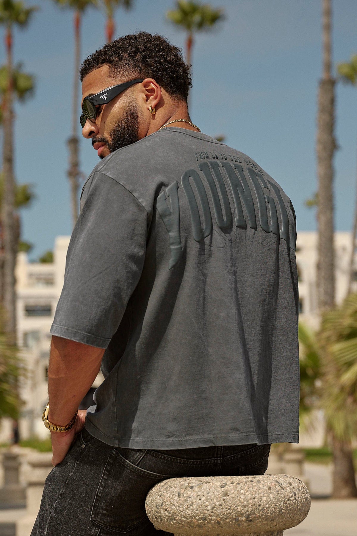 Modelo de espalda con la 4138 Foundation Cropped Tee Black Wash, logo YOUNGLA en la espalda